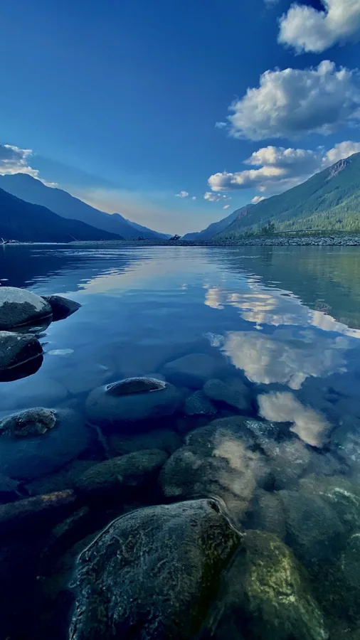 Mountain lake reflecting clouds and a blue sky among rocks