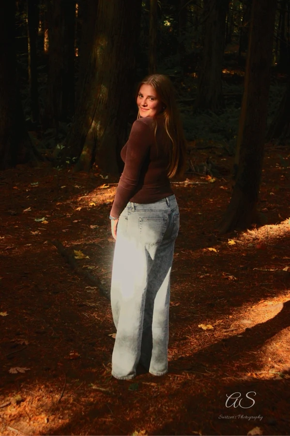 Young woman glancing back over her shoulder on a forest trail